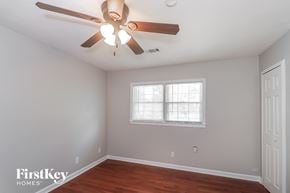 Lawrenceville house for rent - a bedroom with a ceiling fan and a window