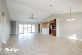 Cape Coral house for rent - A spacious living room with a ceiling fan and a chandelier.