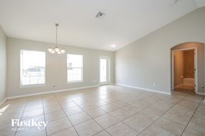 Cape Coral house for rent - A spacious room with a chandelier and a door on the right side.