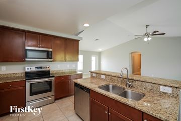Cape Coral house for rent - A kitchen with brown cabinets and granite countertops.