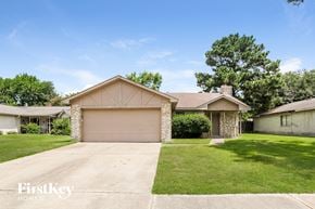 Katy house for rent - a home with a garage door and a lawn