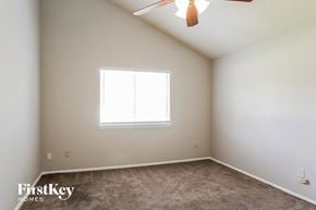 Katy house for rent - a bedroom with a ceiling fan and a window