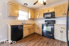 Kearney house for rent - a kitchen with wooden cabinets and black appliances