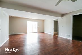 Kearney house for rent - an empty living room with wood floors and a ceiling fan