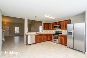 Forney house for rent - a kitchen with stainless steel appliances and wooden cabinets