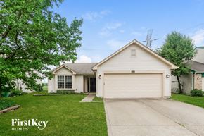 Indianapolis house for rent - a white house with a driveway and a white garage door