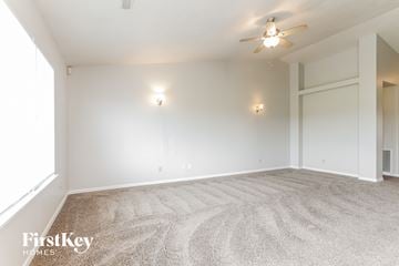 Indianapolis house for rent - a living room with carpet and a ceiling fan