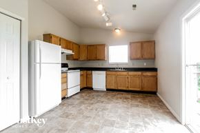 Indianapolis house for rent - an empty kitchen with white appliances and wooden cabinets