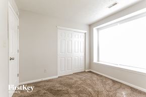 Indianapolis house for rent - a bedroom with carpet and a window and a white door