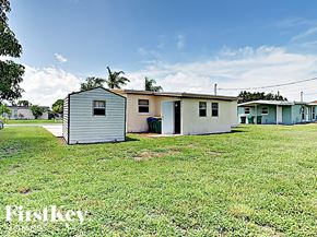 Port Charlotte house for rent - A row of mobile homes in a grassy area with a blue sky above.