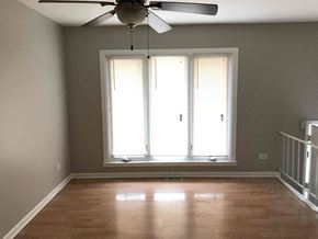 Richton Park house for rent - a living room with a large window and a ceiling fan