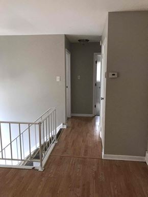 Richton Park house for rent - an empty hallway with a staircase and a door to a hallway with wood flooring