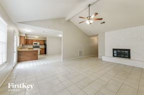 Spring house for rent - A spacious living room with a fireplace and a ceiling fan.