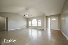 Cape Coral house for rent - A spacious room with a ceiling fan and two windows.