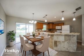 Cape Coral house for rent - A dining room with a table set for two and a kitchen in the background.