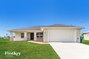 Cape Coral house for rent - a white house with a garage door and a lawn