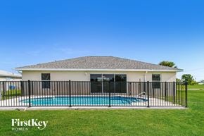 Cape Coral house for rent - a pool in front of a house with a fence