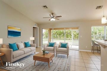 Cape Coral house for rent - A living room with a couch, chairs, and a painting on the wall.