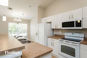 Cape Coral house for rent - A kitchen with a wooden counter top and white cabinets.