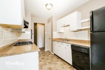 Florissant house for rent - A kitchen with a black refrigerator and white cabinets.