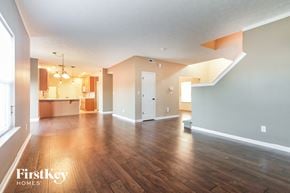 Avon house for rent - A spacious room with wooden floors and a large window on the left side.