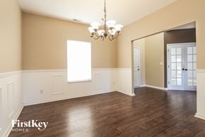 Avon house for rent - A large empty room with wooden floors and a chandelier.