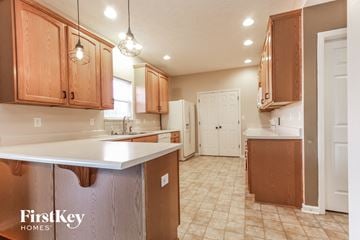 Avon house for rent - A kitchen with wooden cabinets and a white countertop.