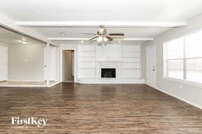 Spring house for rent - A spacious room with a fireplace and a ceiling fan.