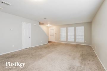 Katy house for rent - a spacious living room with carpet and a white door
