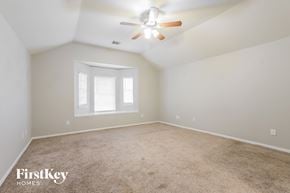 Katy house for rent - a bedroom with carpet and a ceiling fan and a window