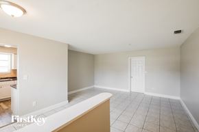 Miami Gardens house for rent - A spacious empty room with a kitchen area in the background.