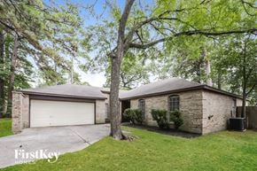 Spring house for rent - a brick house with a garage and a tree
