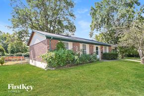 Florissant house for rent - A house with a green roof and a fence in the background.