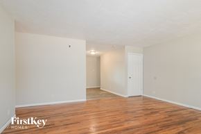 Florissant house for rent - A room with wooden floors and white walls, with a door on the right side.