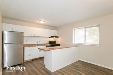 Florissant house for rent - A kitchen with a refrigerator, sink, and cabinets.