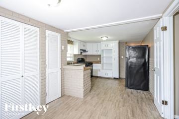 Arnold house for rent - A kitchen with white cabinets and a black refrigerator.