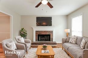 Helena house for rent - A living room with a fireplace and a flat screen TV mounted above it.