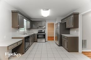 Helena house for rent - A kitchen with a tile floor and a range hood.