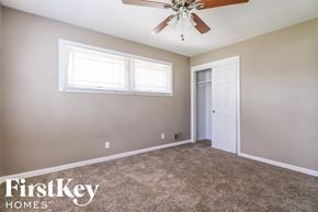 Gladstone house for rent - a bedroom with carpet and a ceiling fan