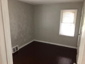 Detroit house for rent - A room with a window and a wall-mounted air conditioner unit.