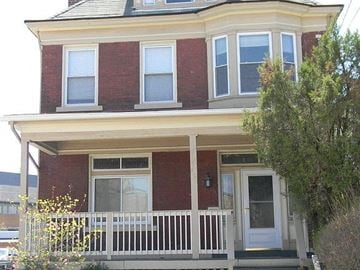 Pittsburgh house for rent - A red brick house with a white door and windows.