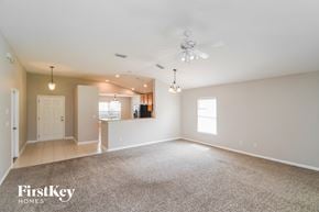 St. Augustine house for rent - an empty living room with a ceiling fan and a kitchen
