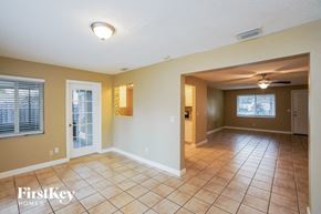 Largo house for rent - a large living room with tile flooring and a white door