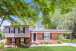 Winston-Salem house for rent - a small brick house with blue shutters and a tree