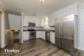 Winston-Salem house for rent - a kitchen with stainless steel appliances and white cabinets