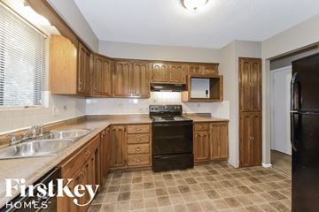 Blue Springs house for rent - A kitchen with wooden cabinets and a black refrigerator.