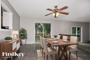 Florissant house for rent - A dining room with a wooden table and chairs, a ceiling fan, and a potted plant.