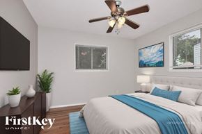 Florissant house for rent - A bedroom with a bed, a ceiling fan, and a painting on the wall.