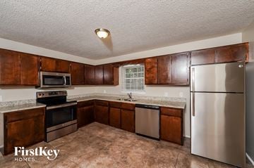 Birmingham house for rent - a kitchen with stainless steel appliances and wooden cabinets