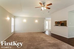 Friendswood house for rent - an empty living room with a ceiling fan and a carpet